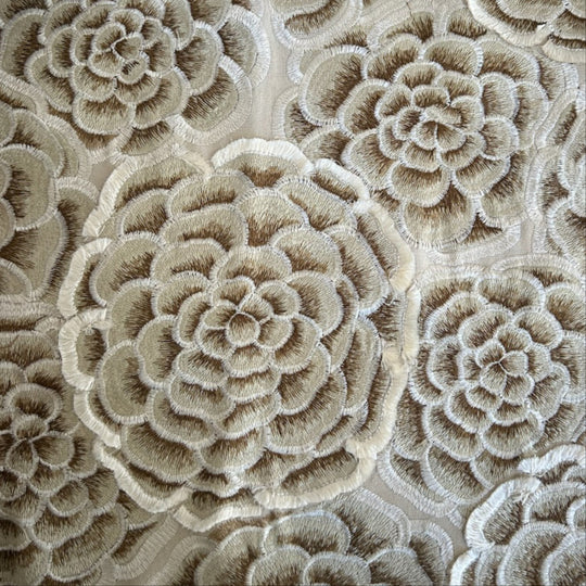 Close-up of a beige and taupe floral embroidered fabric with layered rosette patterns. -  AA-GPU DVAAK-GPU DVAAQ-GPU PWAA2424-GPU PW113616-GPU THAAK-GPU