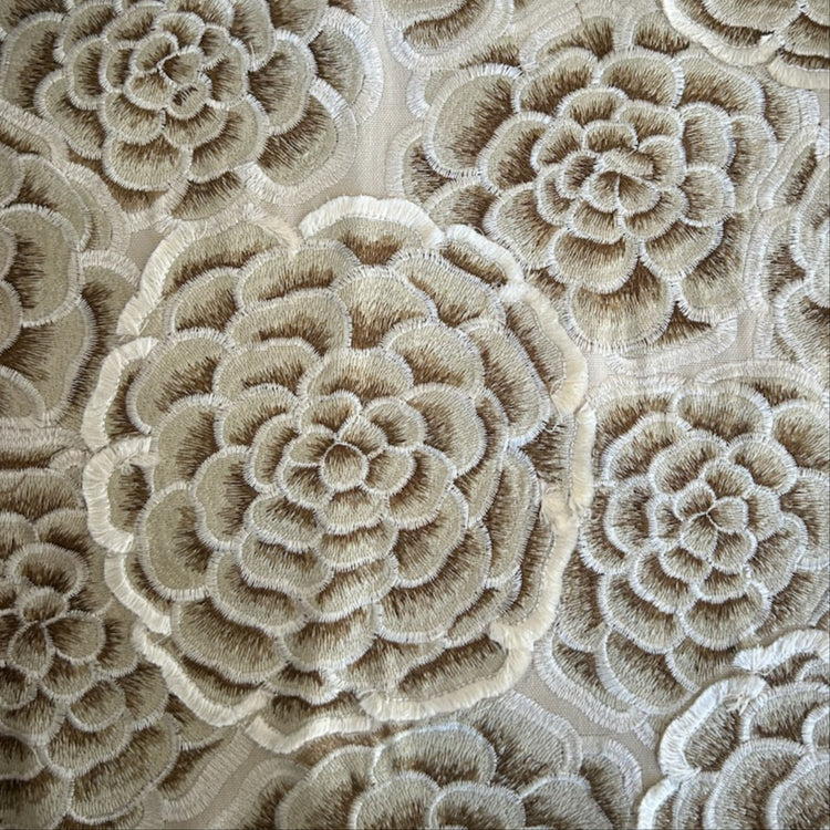 Close-up of a beige and taupe floral embroidered fabric with layered rosette patterns. -  AA-GPU DVAAK-GPU DVAAQ-GPU PWAA2424-GPU PW113616-GPU THAAK-GPU